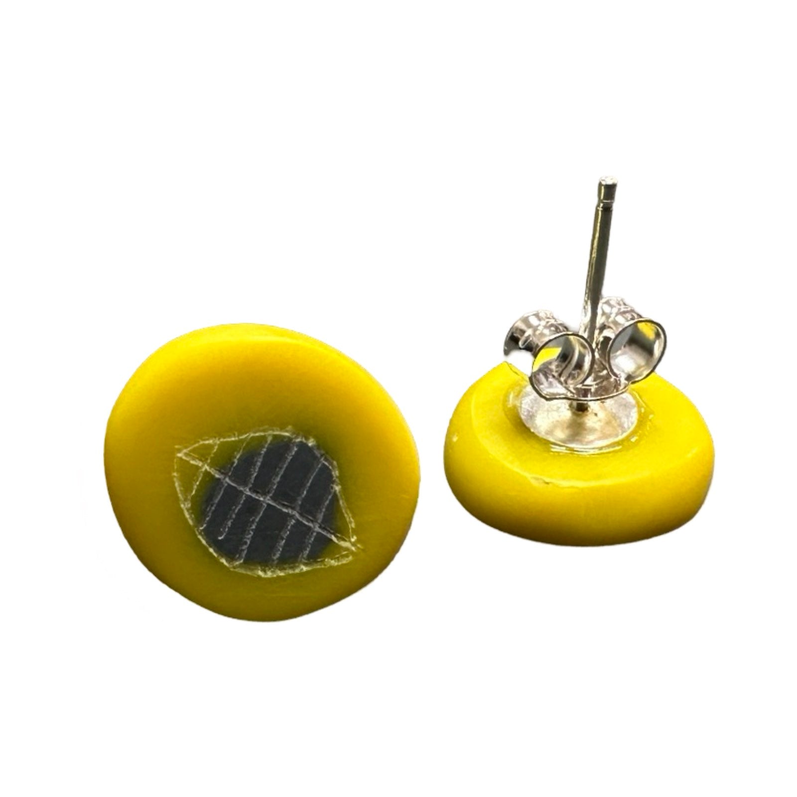 Yellow circular stud earrings with a white engraved leaf and a grey dot with silver ear posts.