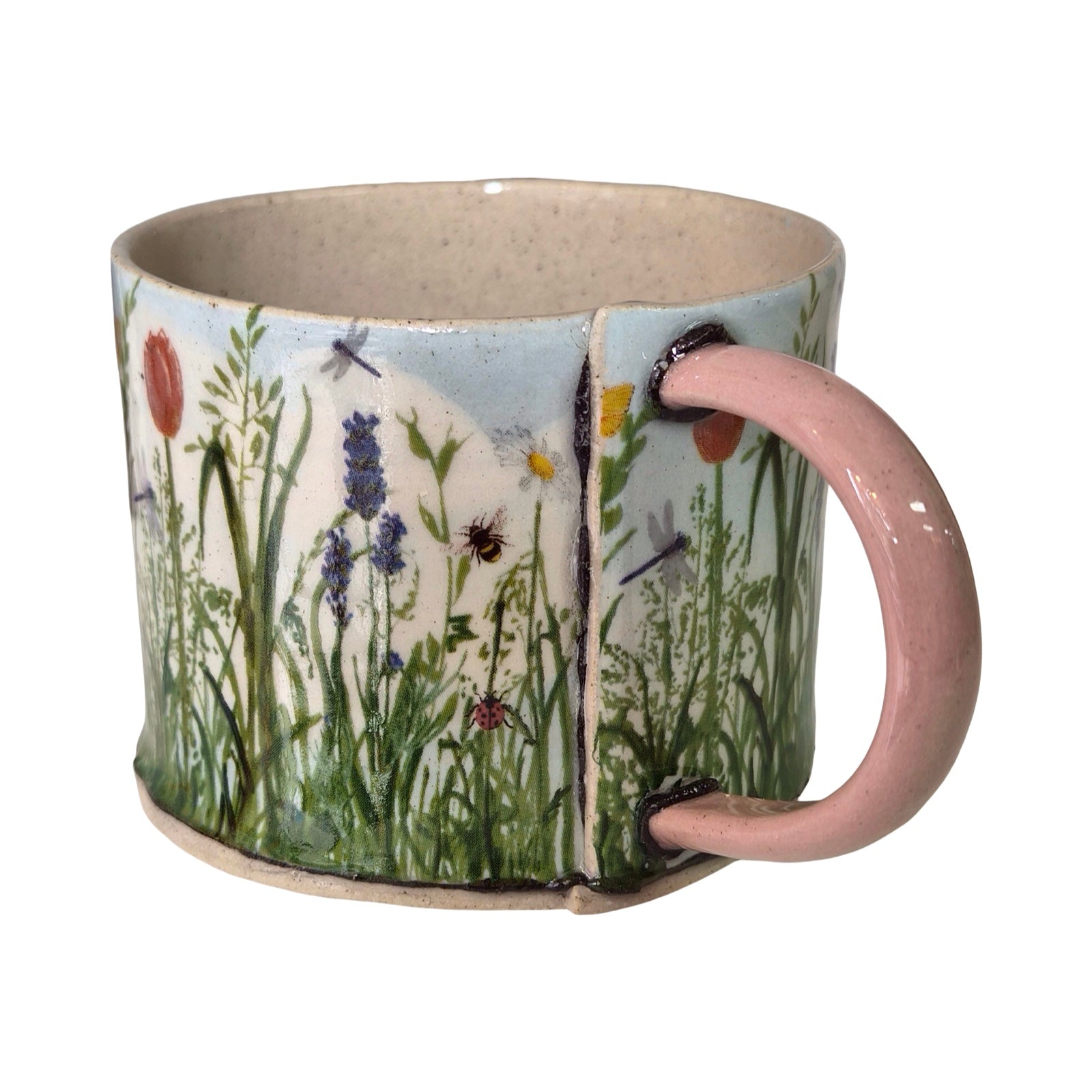 Ceramic mug with nature-themed design featuring flowers and insects on a white background.