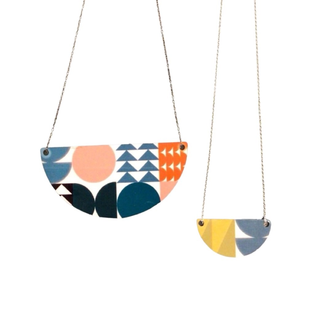 One large and one small geometric arc necklace.