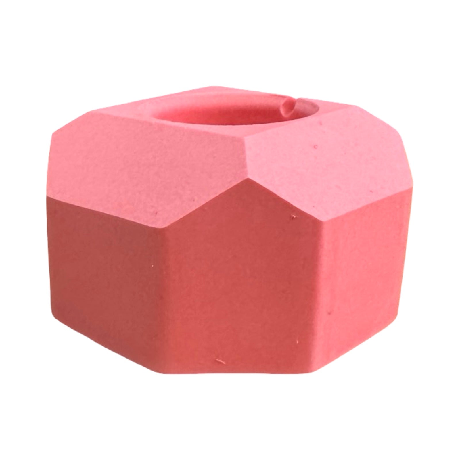 The side of a small geometric shaped dinner candle holder in pink.