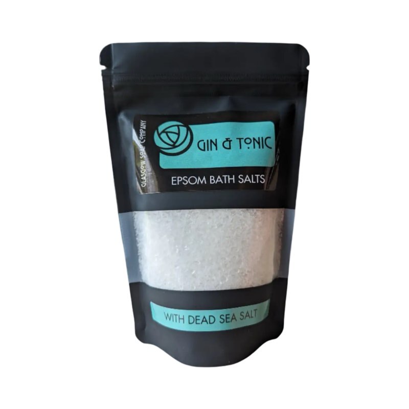 A black packet with a clear panel showing white gin and tonic scented epsom salts.