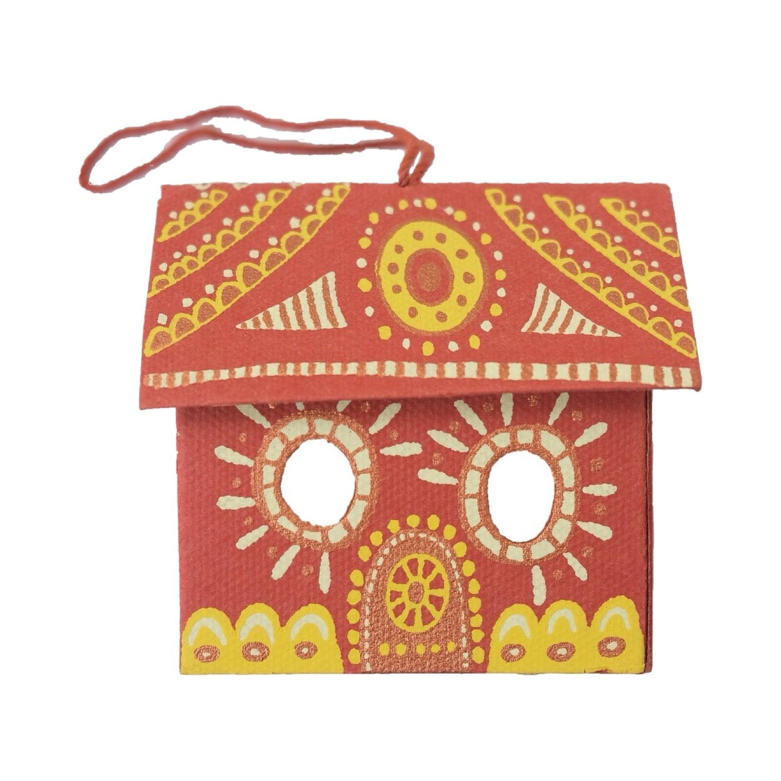 A red and gold gingerbread house three-dimensional decoration.