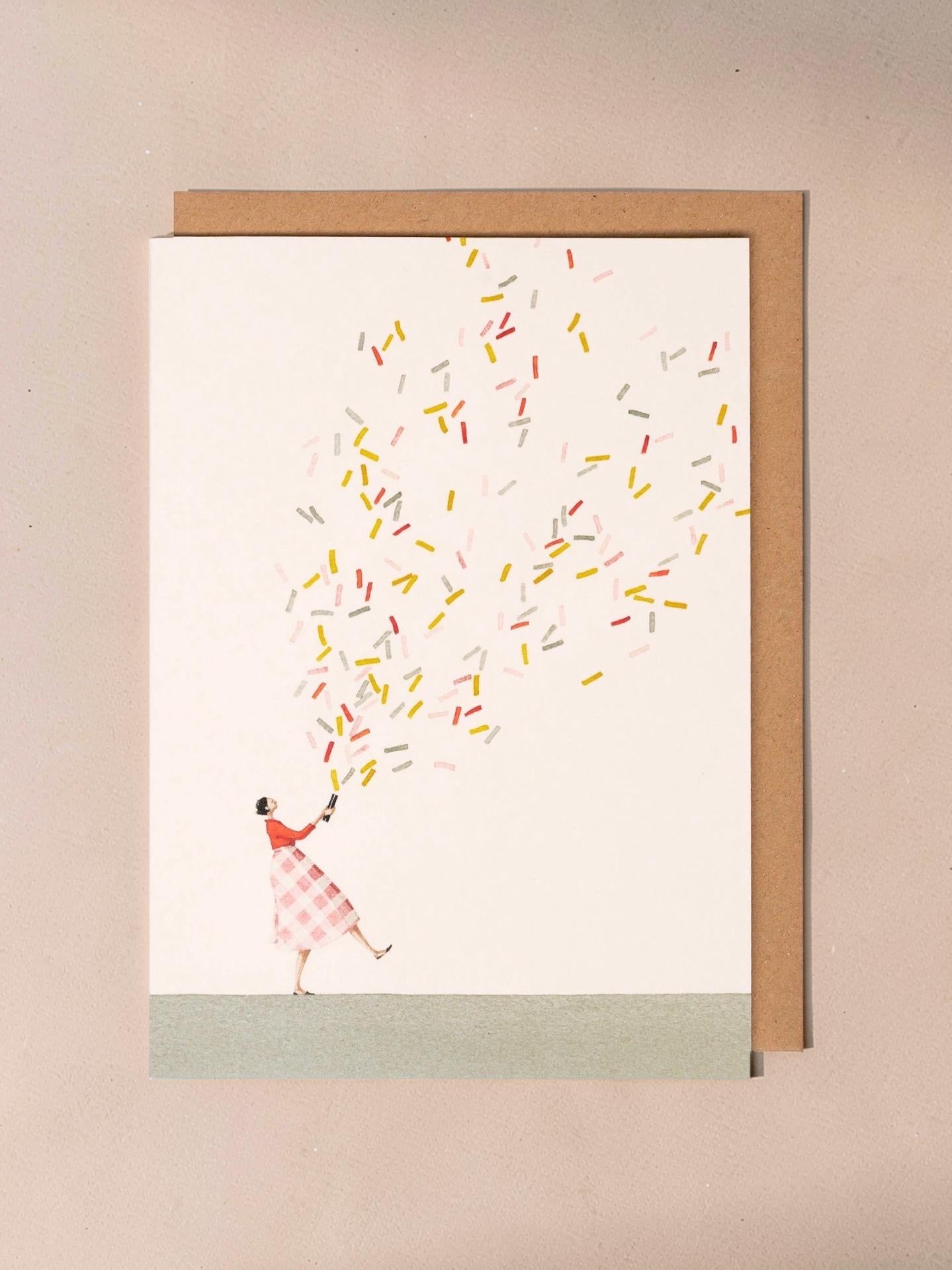 A new baby card featuring an illustration of a lady who has set off a giant glitter bomb on a light background.