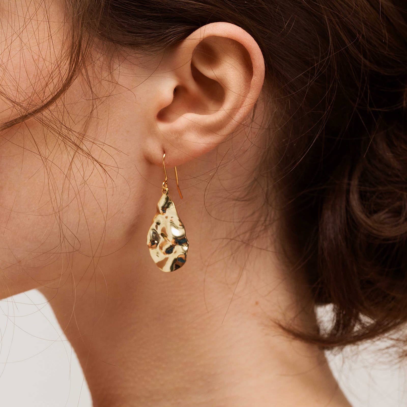 These gold-plated teardrop-shaped earrings are made from brushed brass on gold-plated earring hooks.