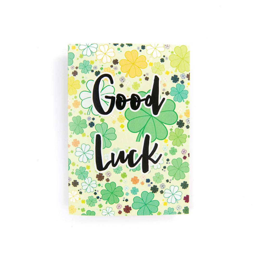 An image of a card with clovers and the words good luck on it.