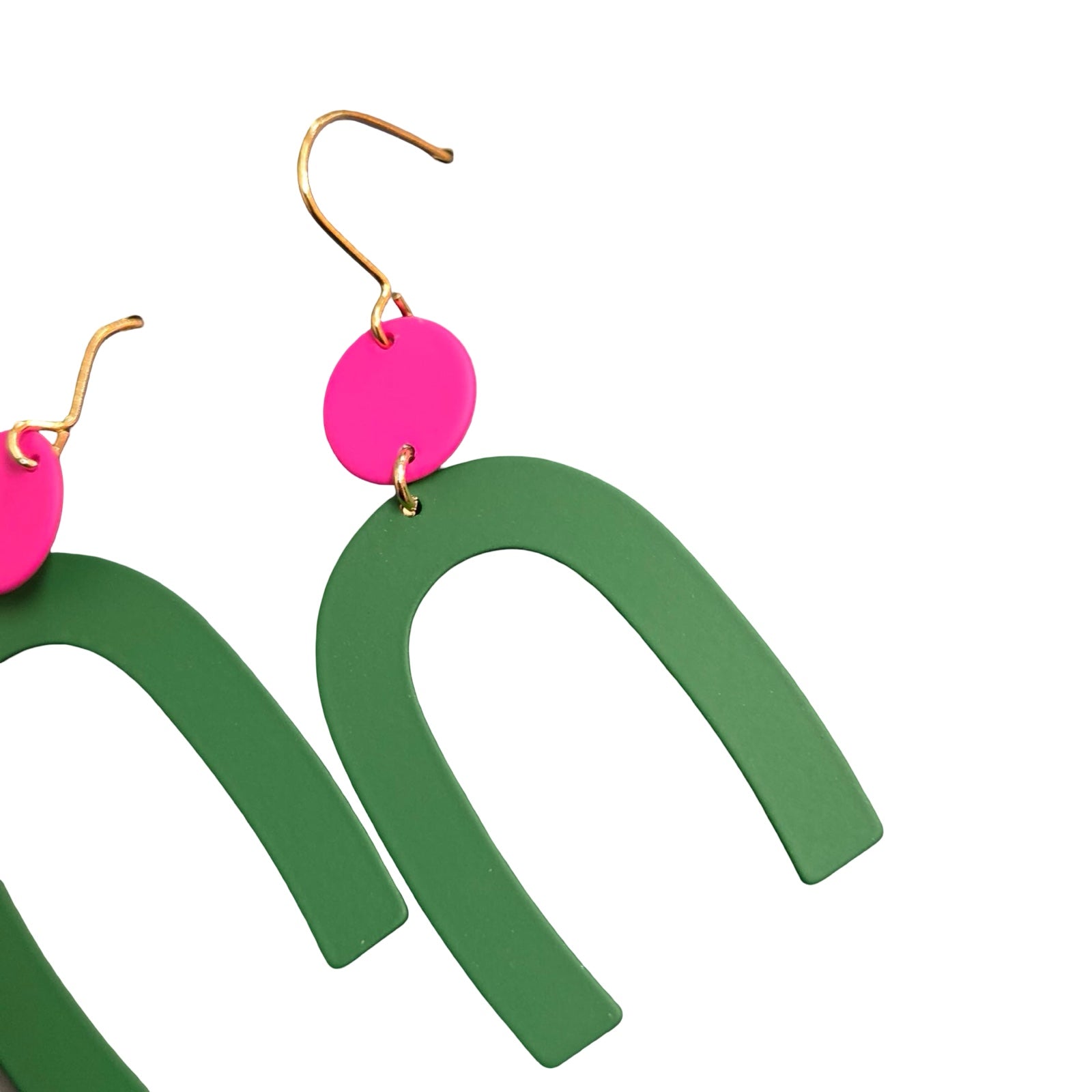 Green arch-shaped earrings with pink circular accents on a white background.