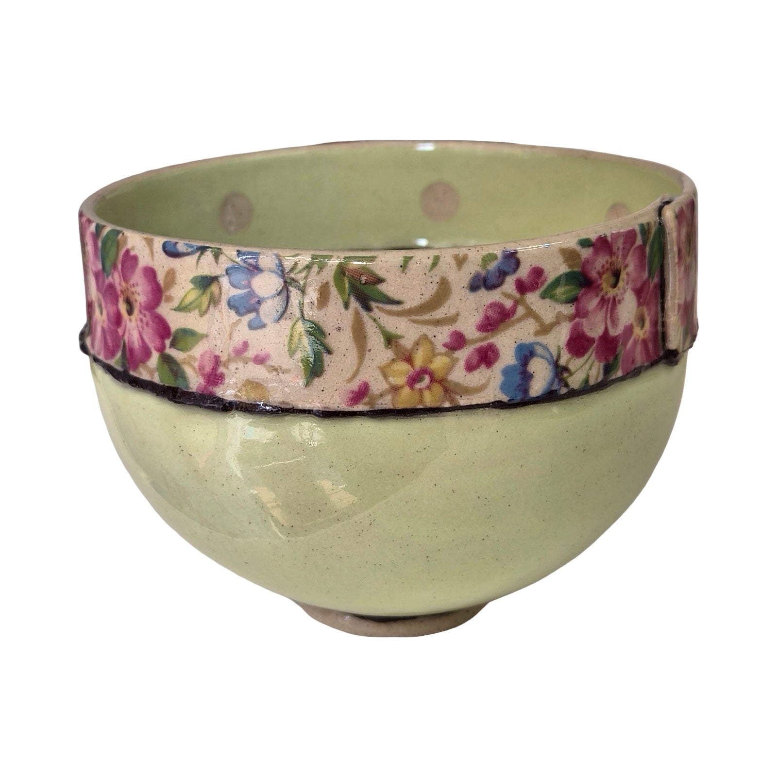 Green ceramic bowl with a floral-patterned band on a white background.