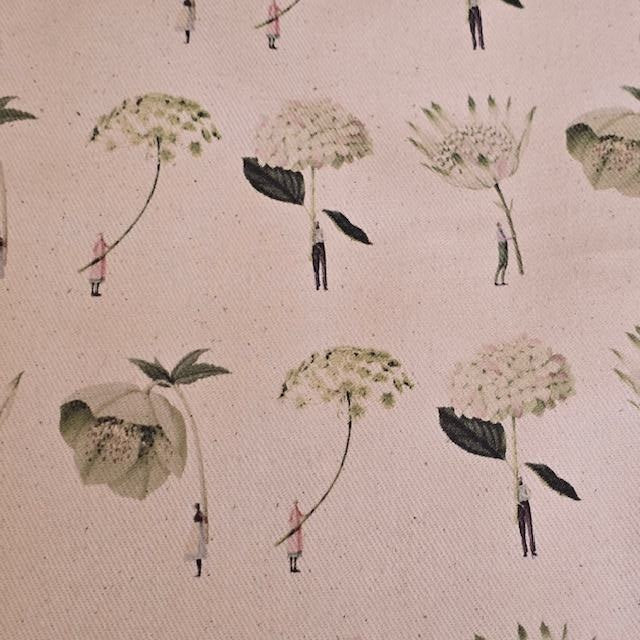 A close up of the fabric from the green flowers apron showing ladies and gentlemen holding giant green and white flowers.
