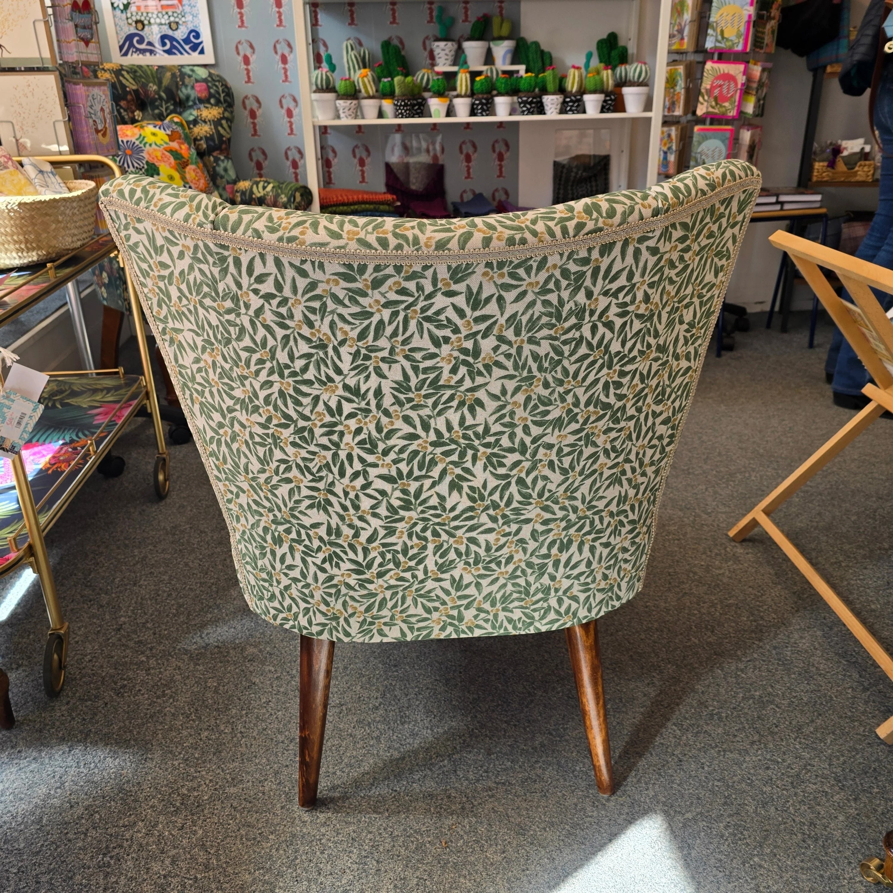 A fabulous cocktail chair covered in beautiful green foliage cotton fabric with mahogany legs.