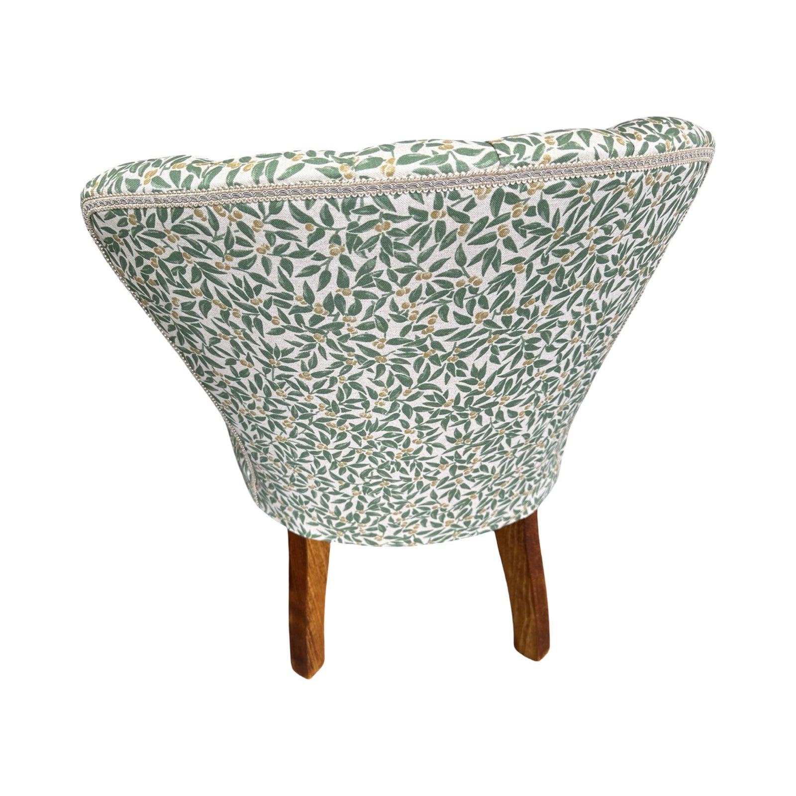Small upholstered chair with leaf pattern on a white background.