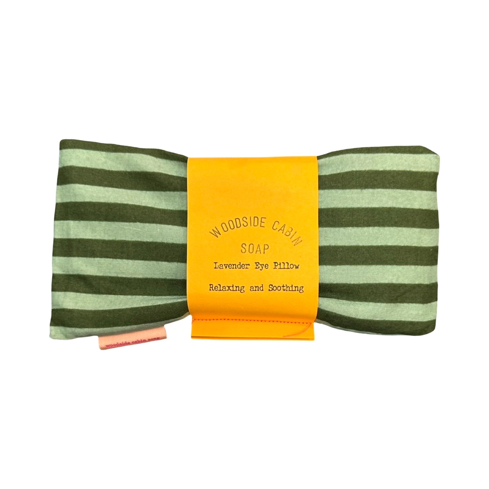 A striped eye pillow with olive green and light sage green horizontal stripes, wrapped in a bright yellow paper.