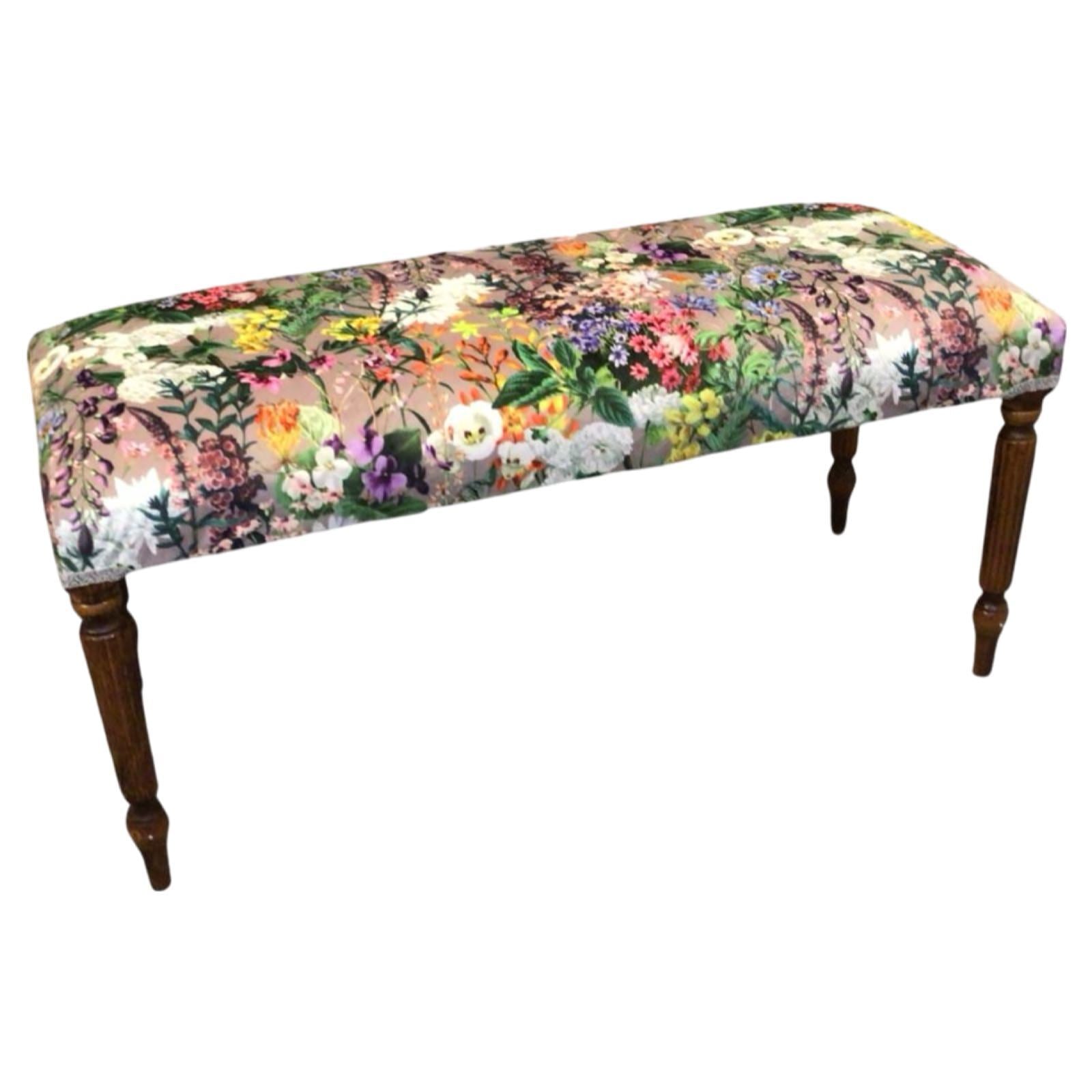 This bench is covered in luxurious grey velvet fabric with bright colourful flowers, finished with cream binding and mahogany legs.