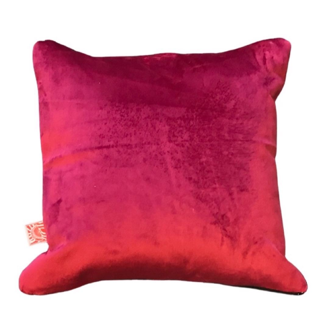 Raspberry pink velvet back of groovy face cushion orange.