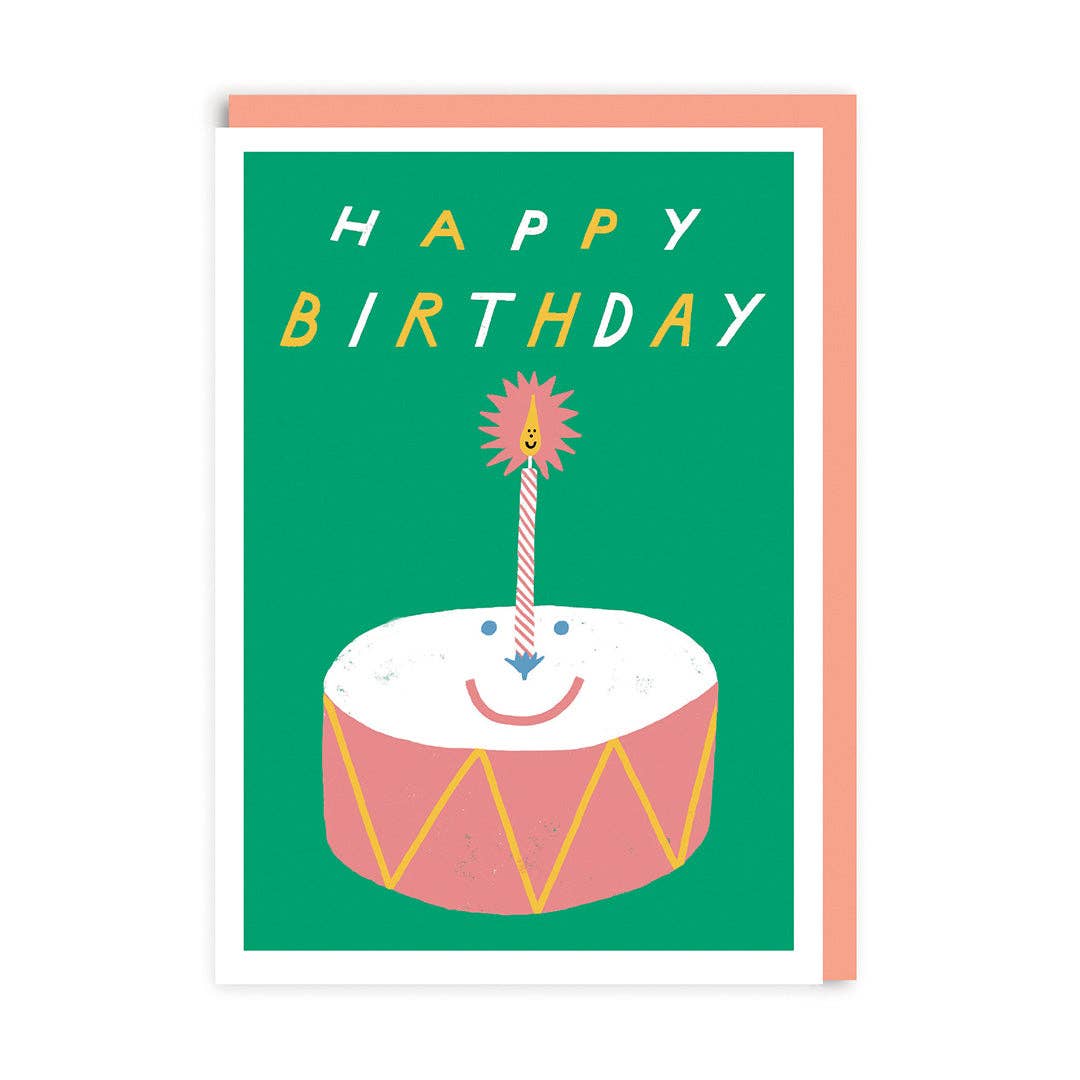 Birthday card featuring an illustration of a drum with a smiling face and a single striped birthday candle in the centre.