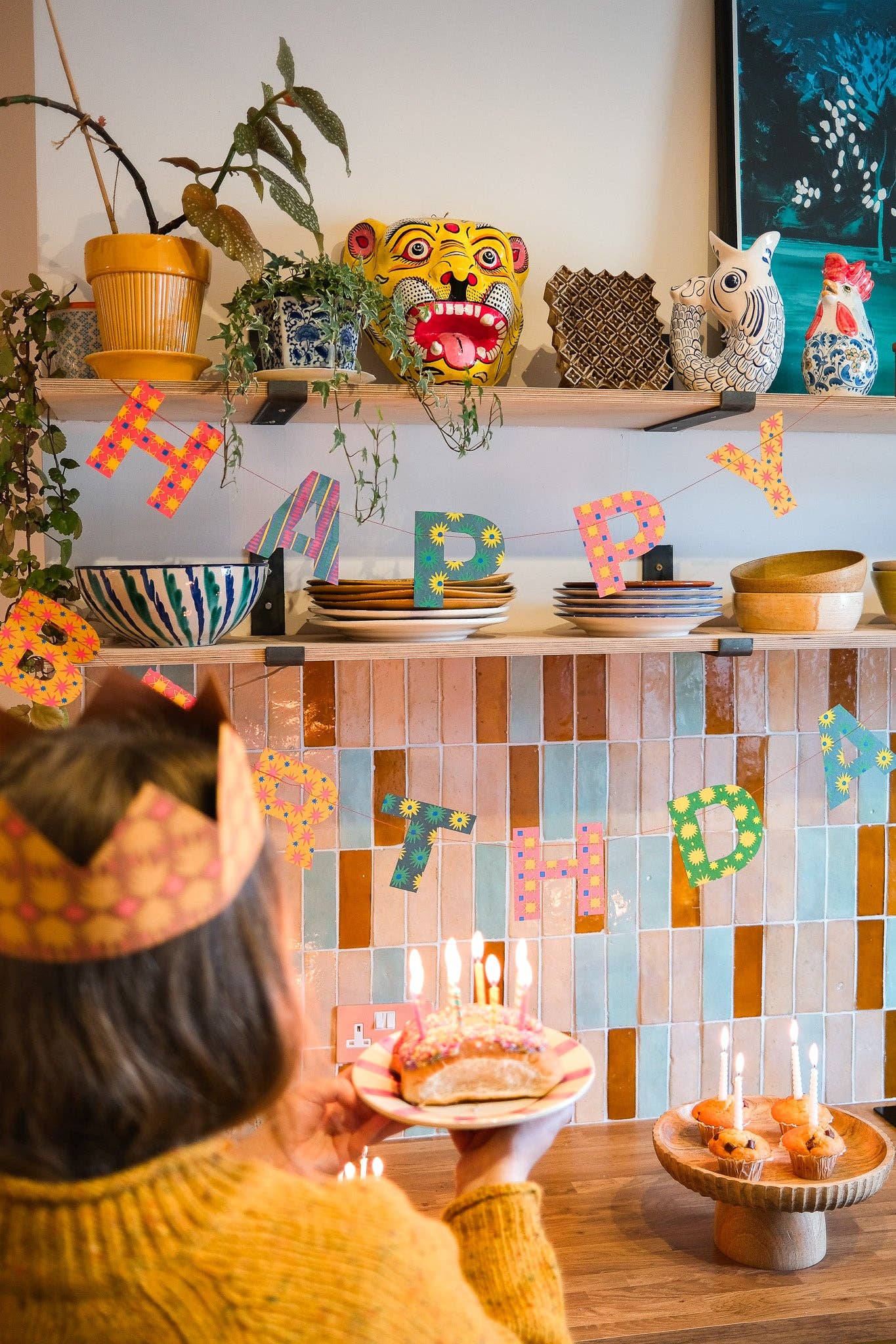 A multicoloured Happy Birthday garland hanging in a kitchen.