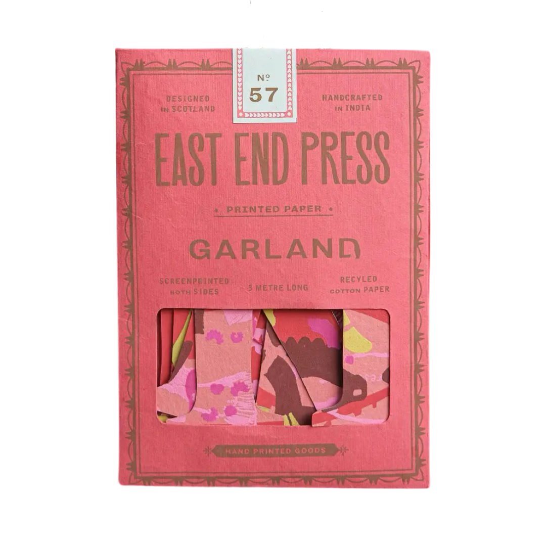A pink paper packet for a Happy Birthday paper garland in red.