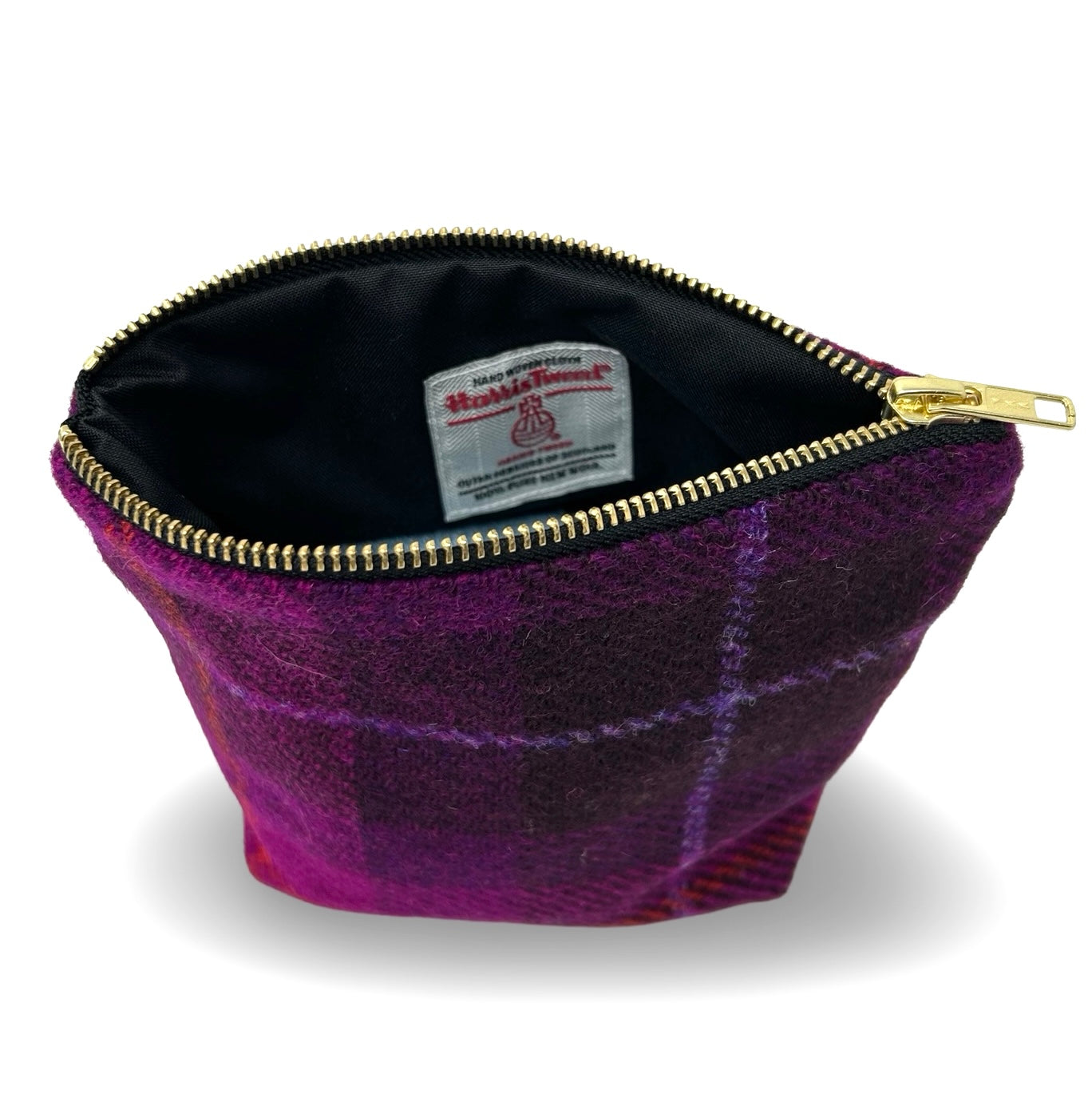 Purple Harris tweed toiletry or make up bag with gold zip. Shown here with the zip open showing the inner black lining with harris twee orb label.