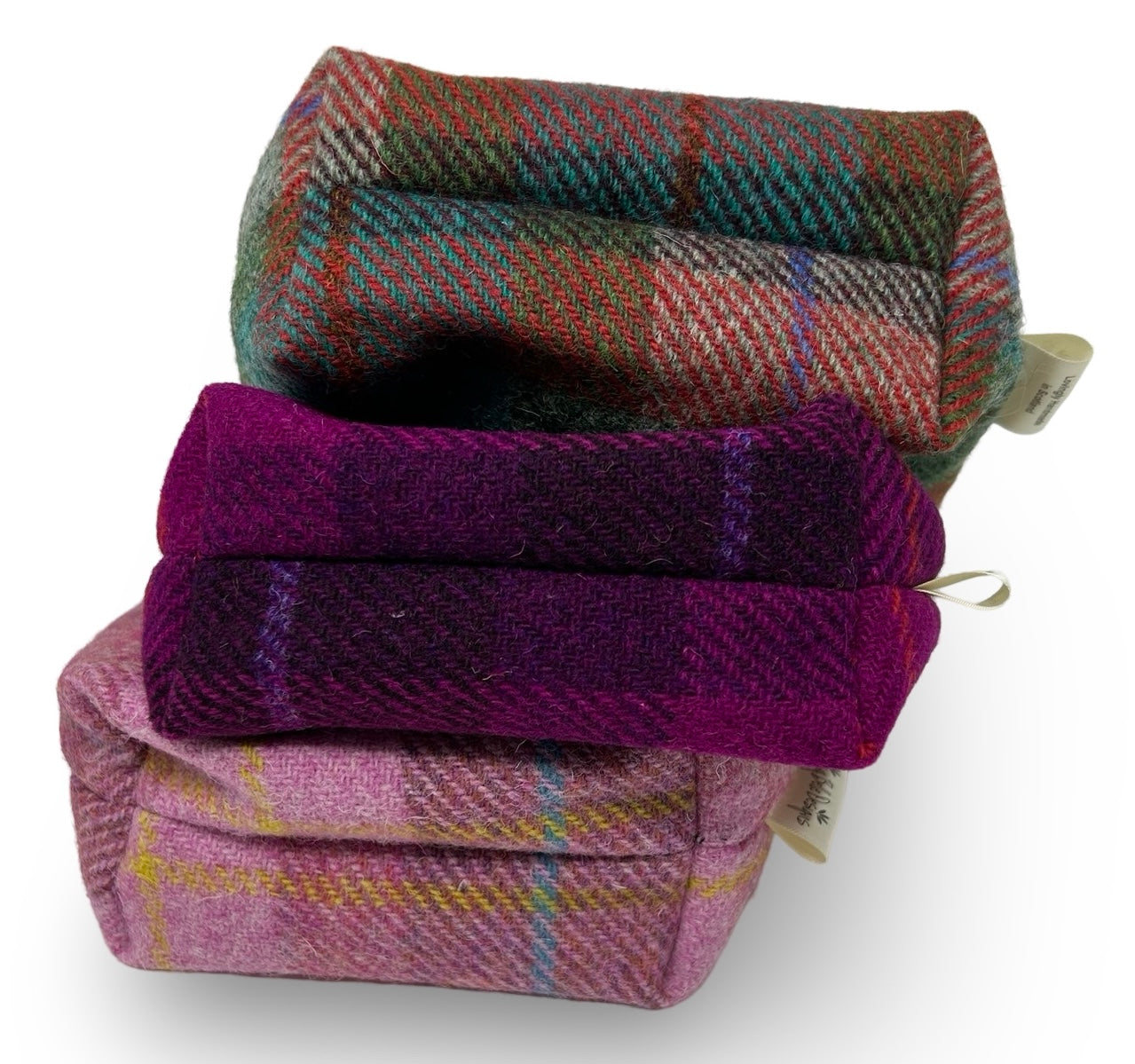 Showing the boxed base of three colours of harris tweed toiletry bag.