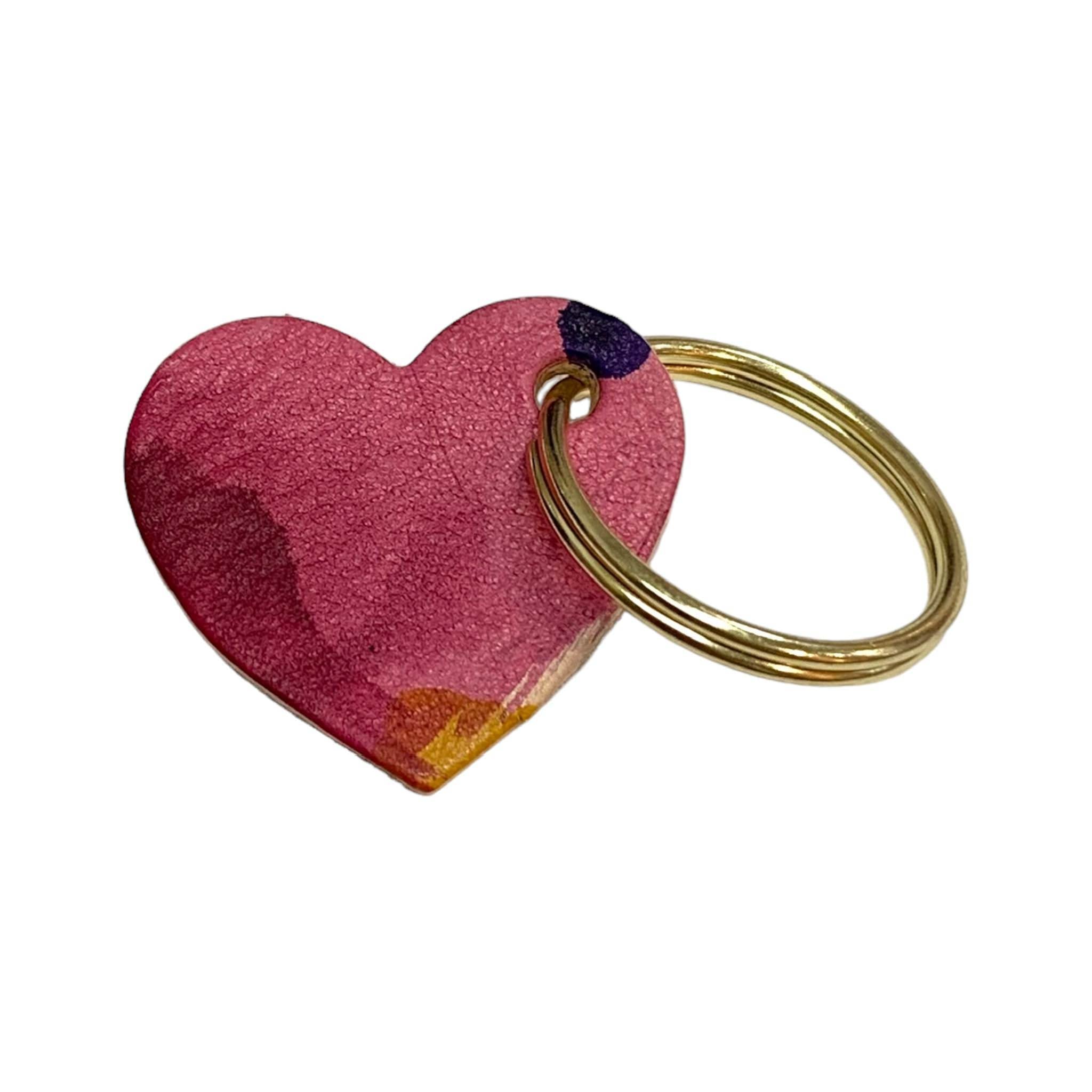 A leather heart-shaped keyring with a brush tone finish and a gold ring.