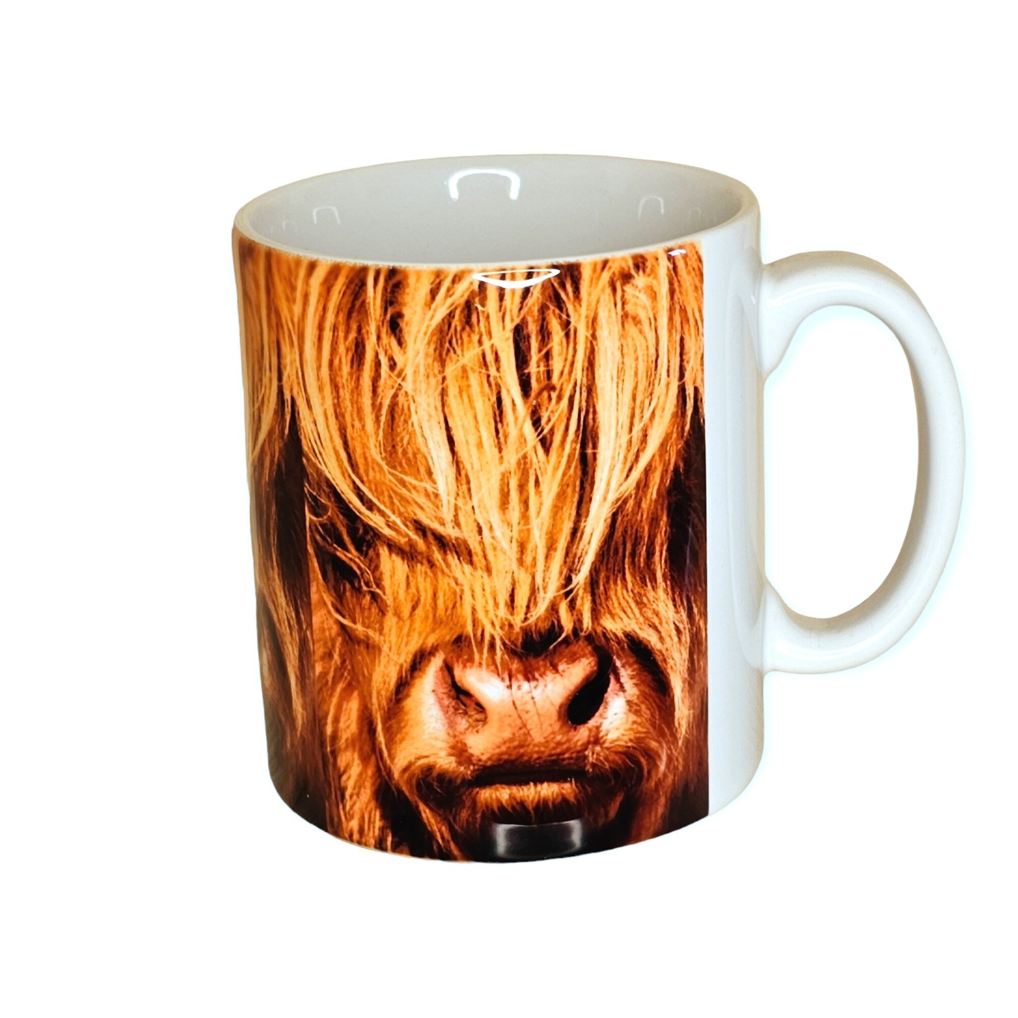 An image of a mug featuring a close up of a Highland Cow.