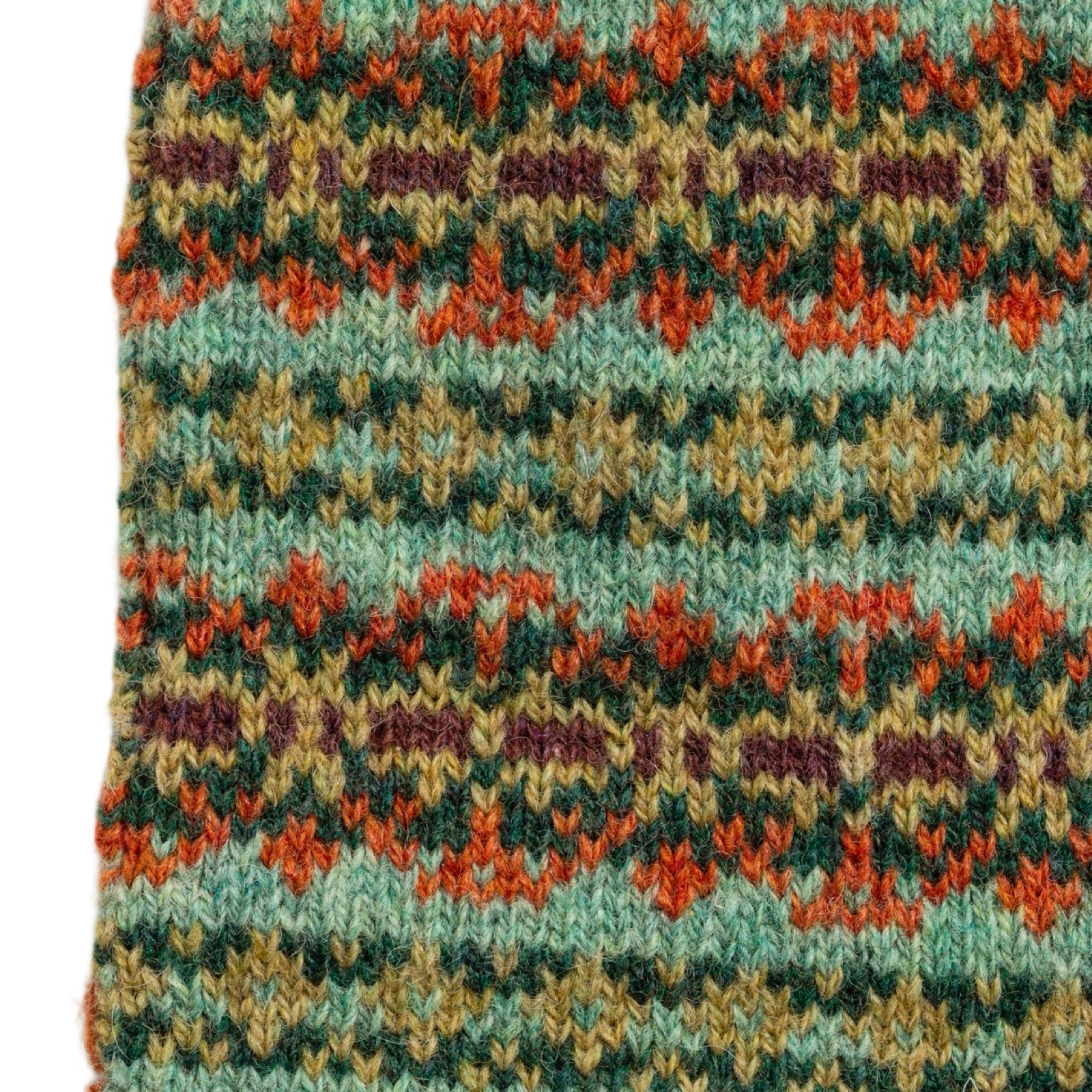 Close-up of a knitted fabric with a colorful pattern on a white background.
