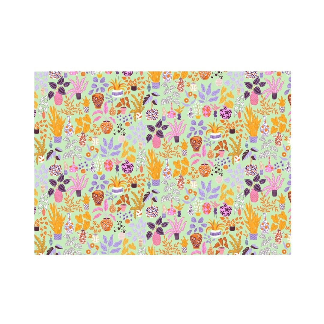 Wrapping paper featuring a colourful selection of house plants on a pale green background.