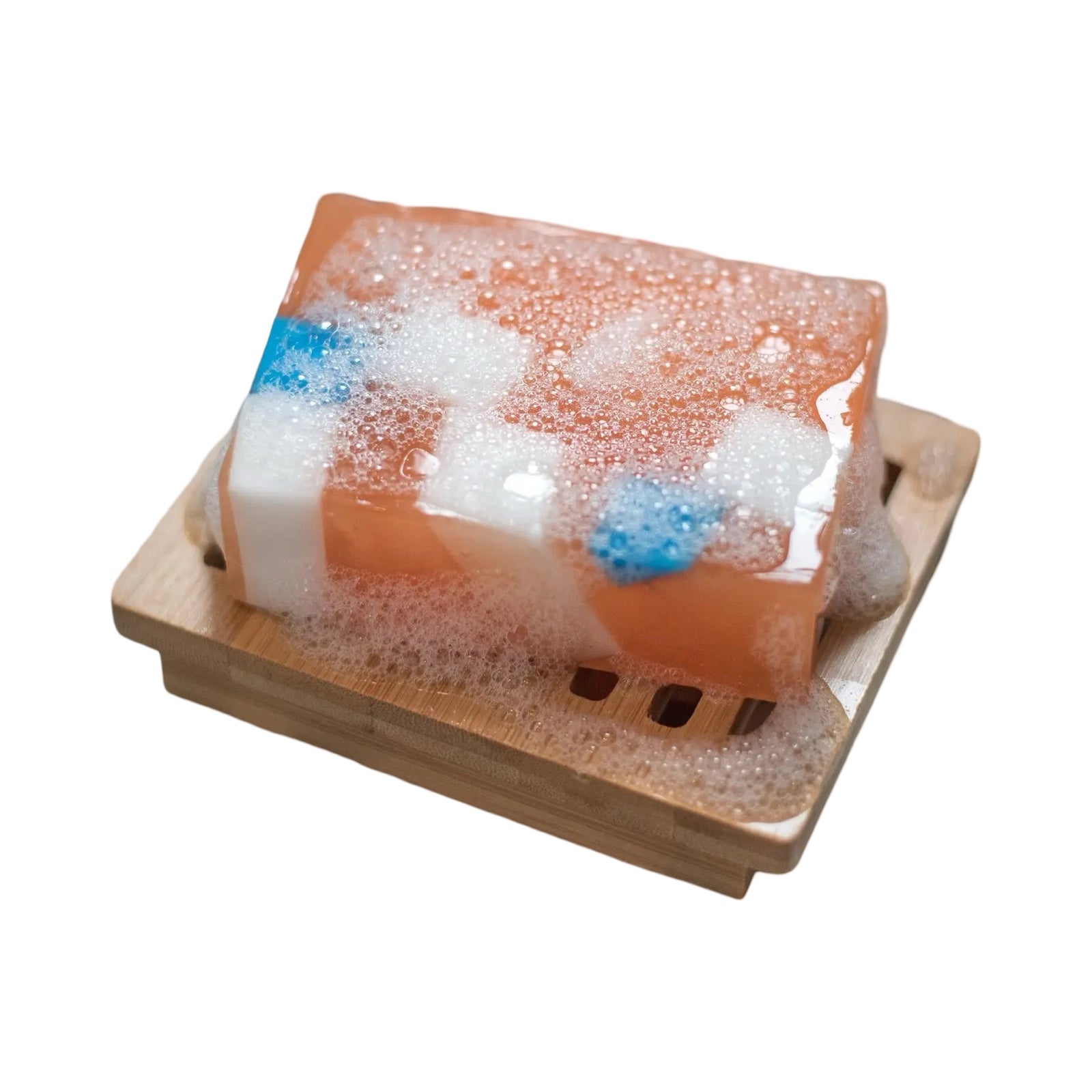 A bar of orange, white and blue iron brew soap sitting on a wooden soap dish.