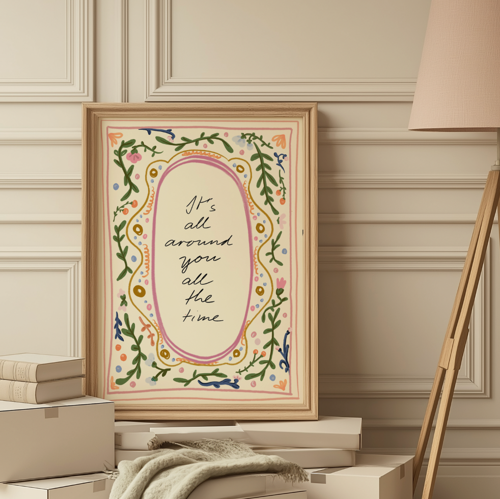 Decorative print with floral border and motivational quote framed, against a wall.