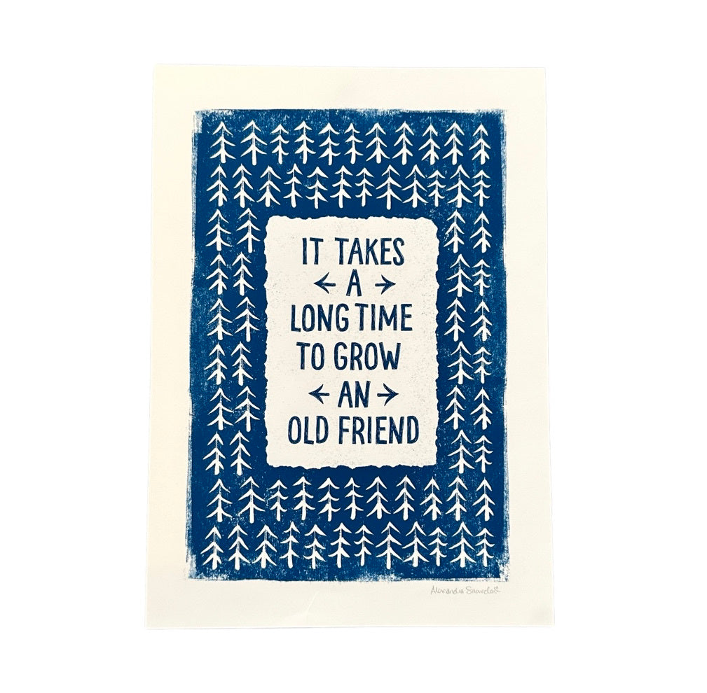 Print with the text 'it takes a long time to grow an old friend' written in navy in a white rectangle in the centre of the print, surrounded by white fir trees on a navy blue background