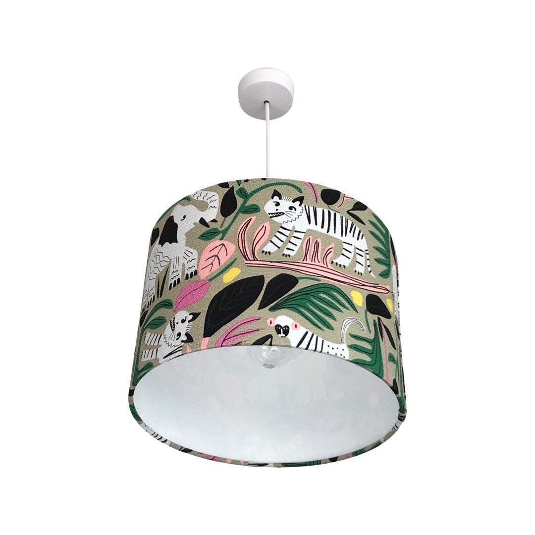 Close up of a drum lampshade with black and white jungle animals and colourful leaves on a grey background