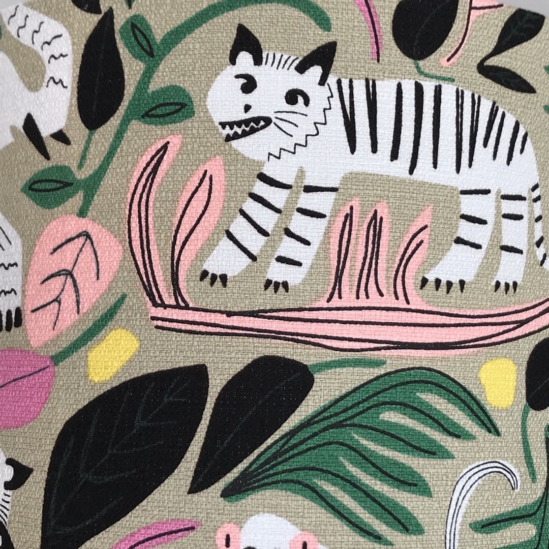 Barkcloth fabric with black and white jungle animals and colourful leaves on a grey background