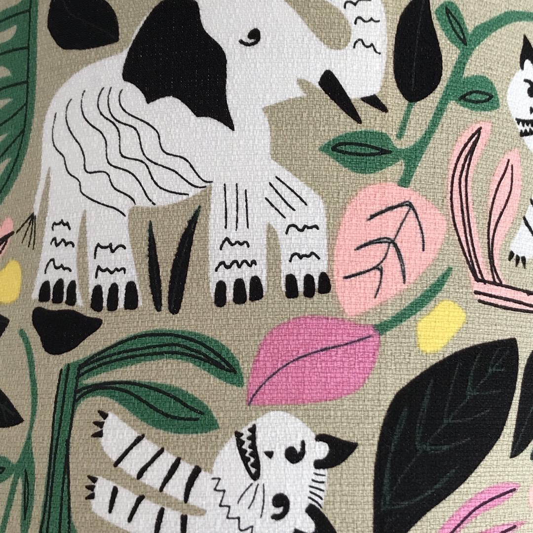 Barkcloth fabric with black and white jungle animals and colourful leaves on a grey background