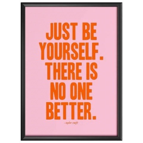 Framed poster with motivational quote 'Just be yourself. There is no one better.' on a pink background.