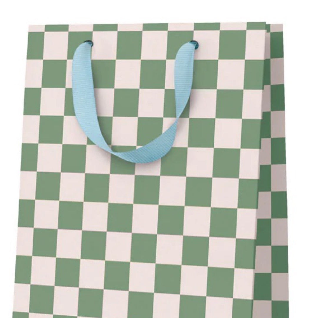 Checkered gift bag with green and white pattern and blue handles on a white background.