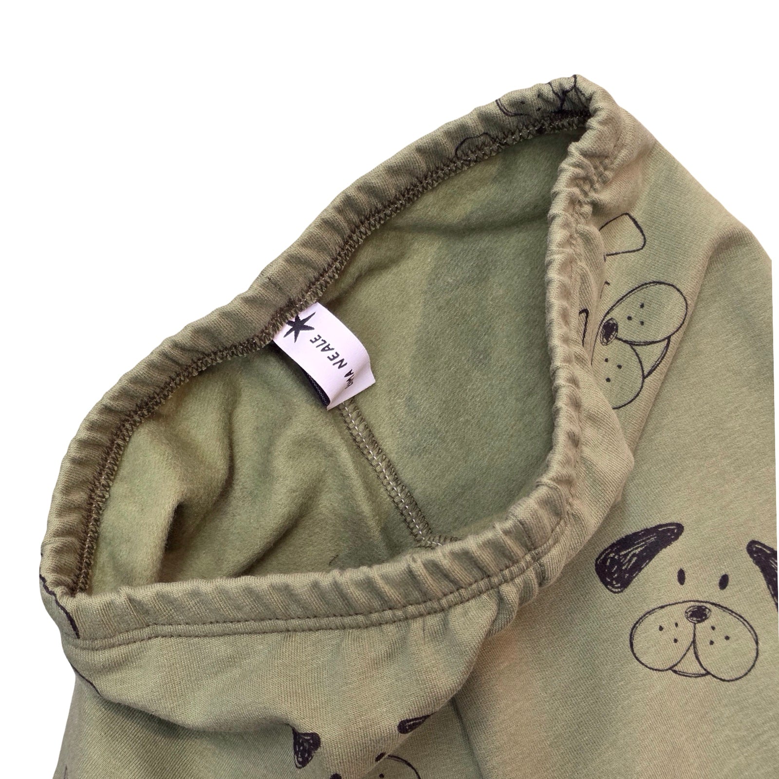 Close-up of a green fabric with a label and dog illustrations on a white background.