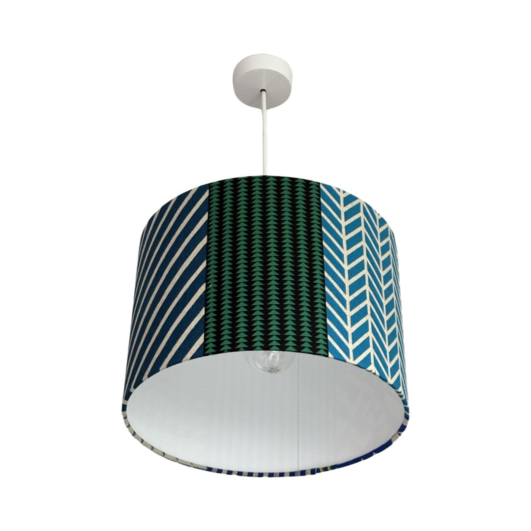 Drum lampshade in panels of blue, grey, green and grey geometric designs