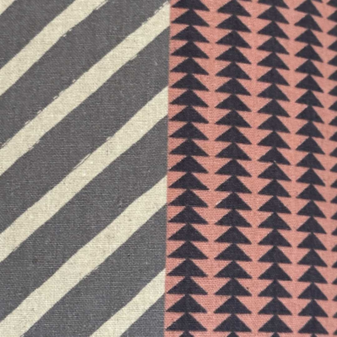 Handmade drum lampshade in panels of pink, grey, navy and cream geometric designs.