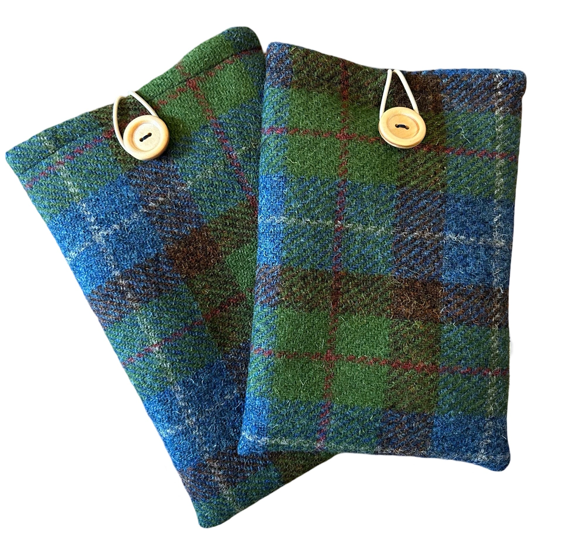 Blue and green tartan Harris tweed kindle sleeves shown here in 2 sizes. The Kindle sleeves have a wooden button and elastic loop to close.