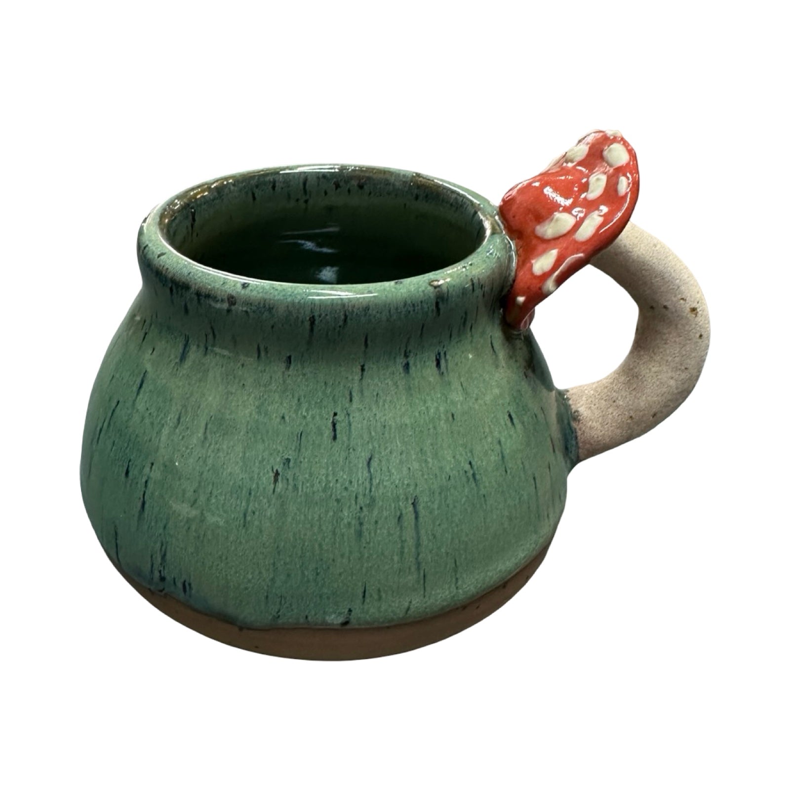 Green ceramic mug with a red mushroom handle on a white background.