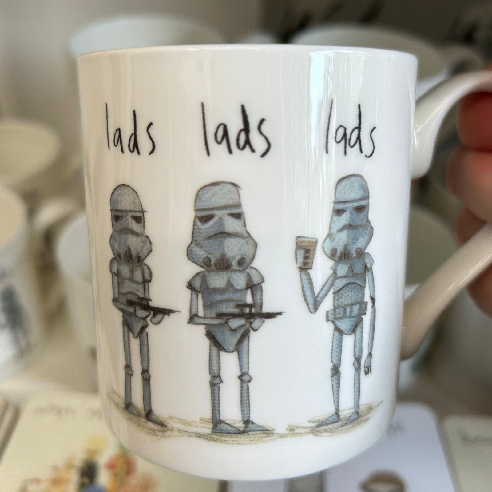 Mug with stormtrooper design and 'lads lads lads' text, held by a hand.