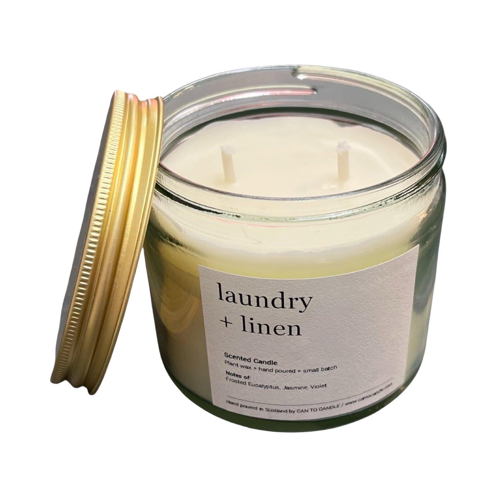 Scented candle labeled 'laundry + linen' with a gold lid on a white background.
