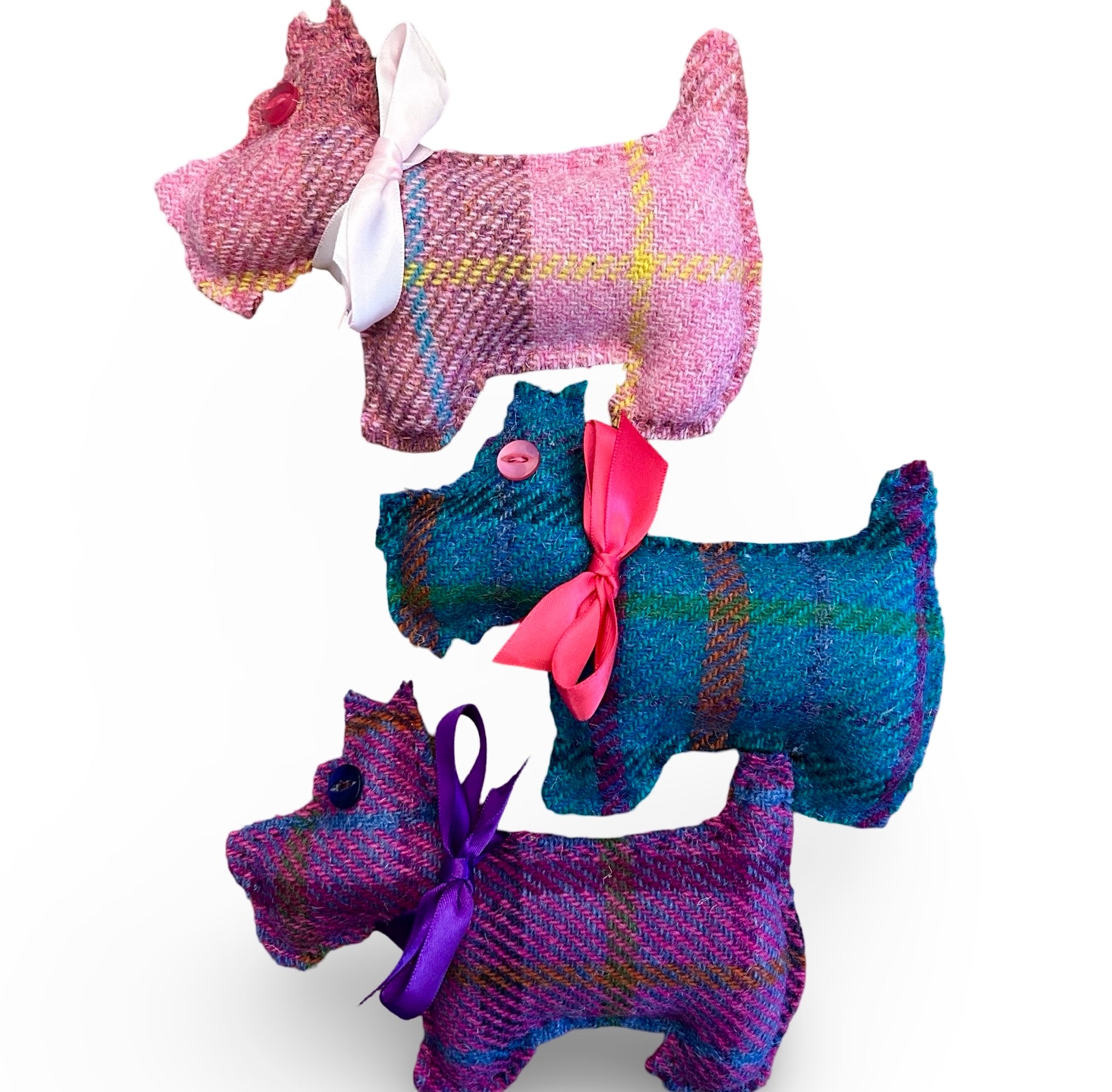 Three colours of Harris tweed lavender filled Scottie Dog.  One is pale pink, one turquoise and one purple.  They have a button eye and a satin ribbon collar.
