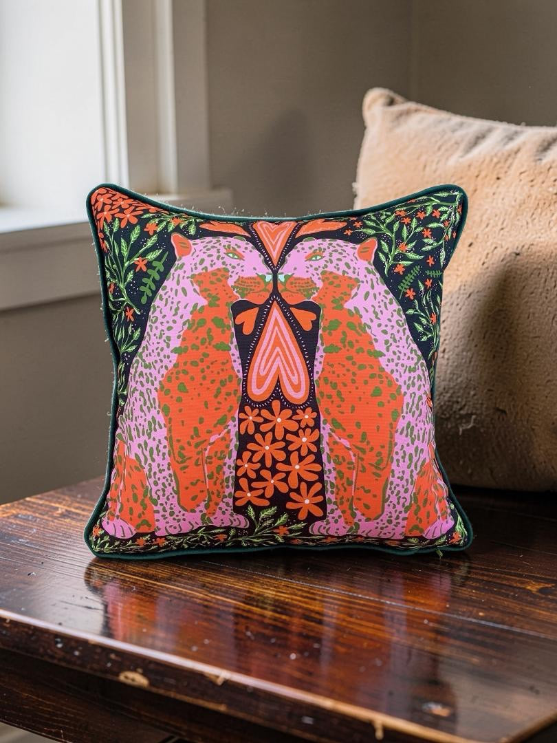 Decorative pillow with colourful patterns on a wooden surface.