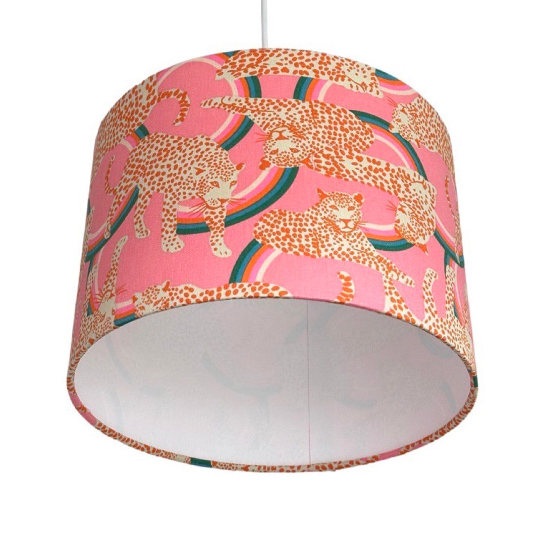 Close up of leopards drum lampshade covered in canvas fabric with white and red leopards on a pink and red background