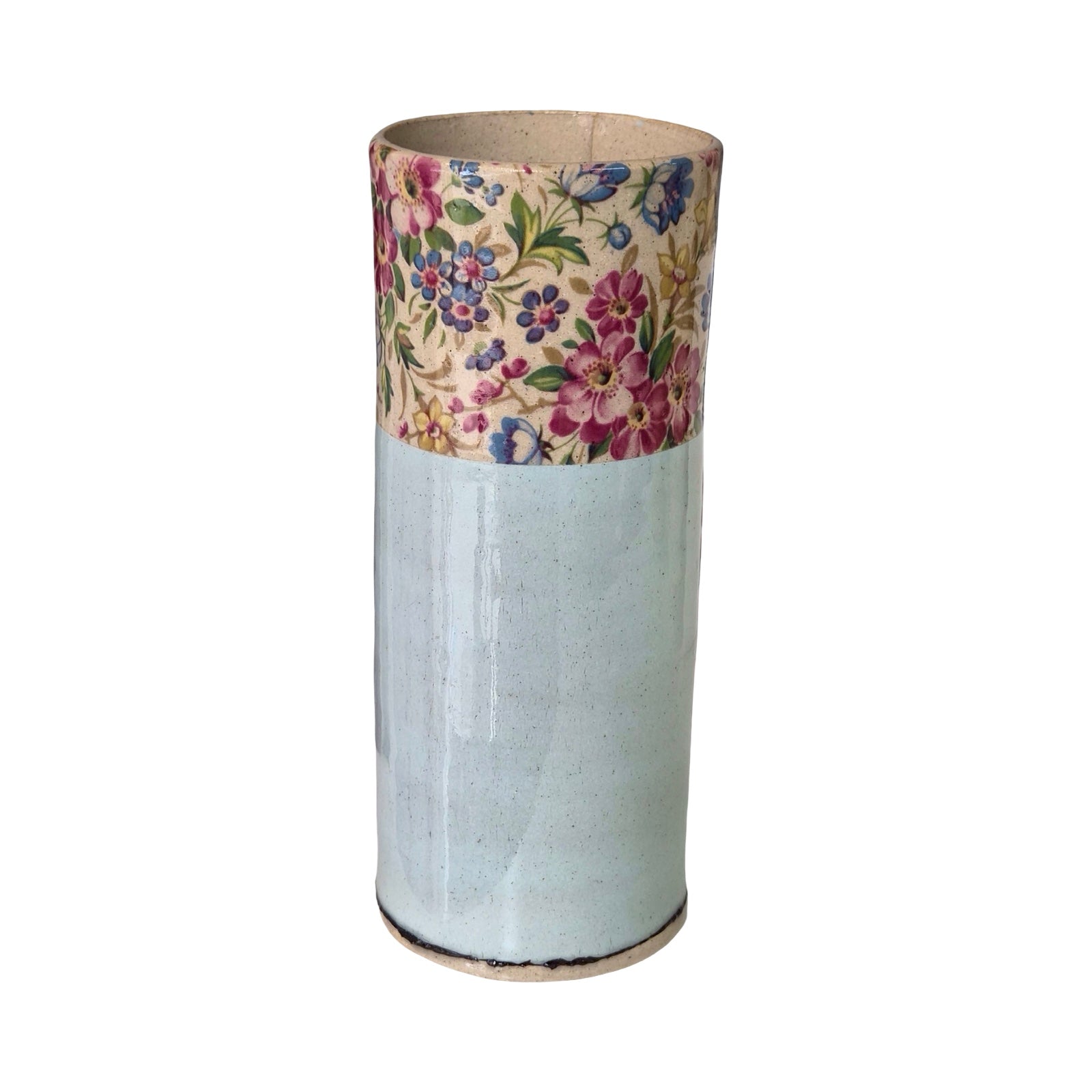 Cylindrical vase with floral patterned top on a white background.