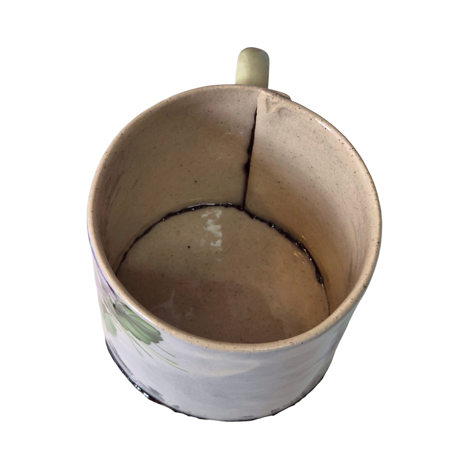 Ceramic mug with a crack running through it on a white background