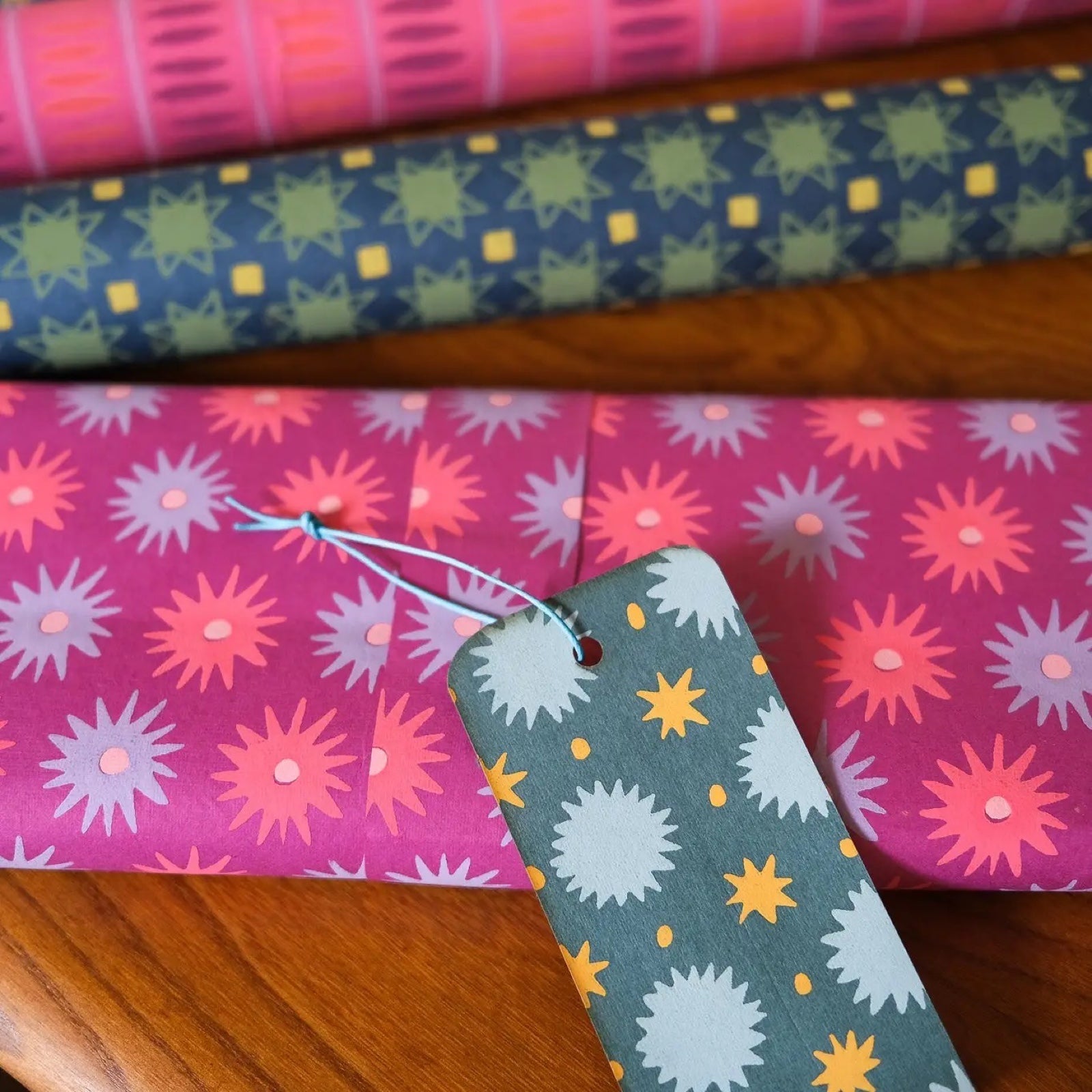 A present wrapped in a sheet of lilac wrapping paper with pink and blue flowers.