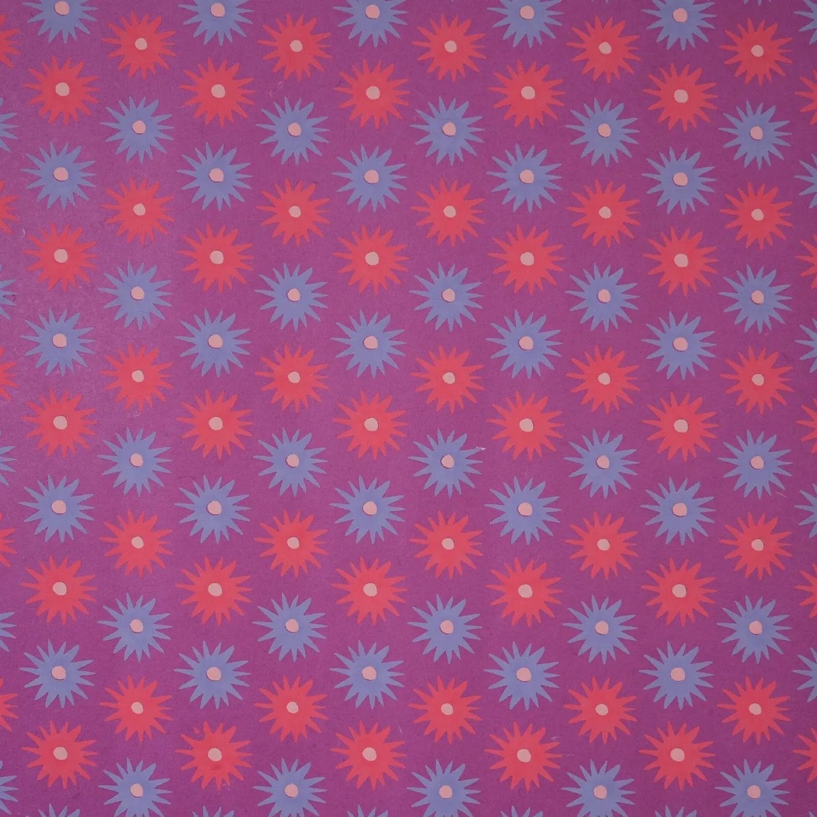 A sheet of lilac wrapping paper with pink and blue flowers.