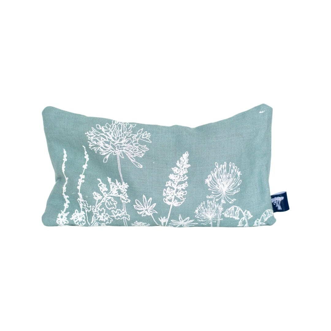 A rectangular linen eye pillow with a floral and coastal pattern, in a duck egg blue colour.