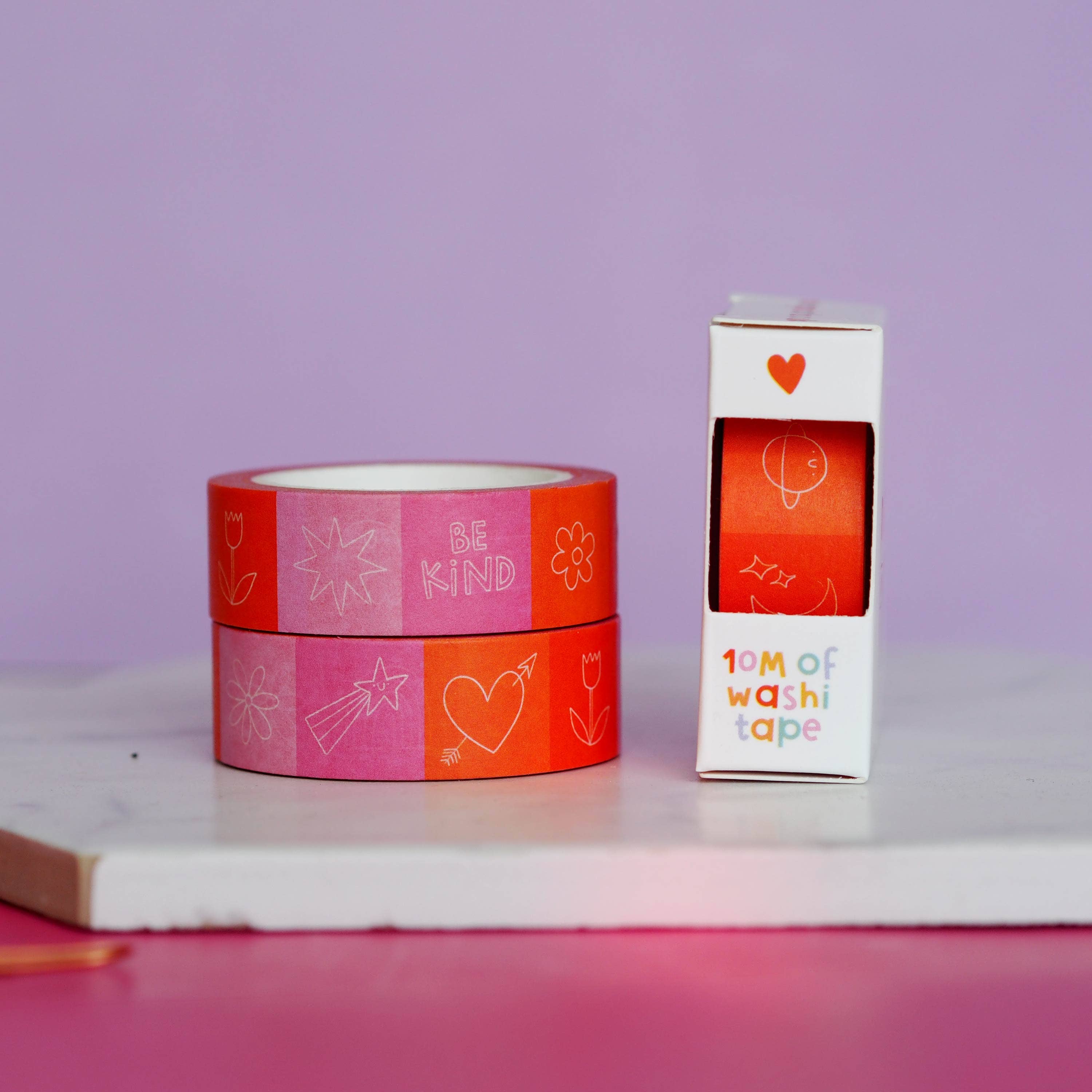 Two rolls of washi tape with a packaging box on a light purple background.